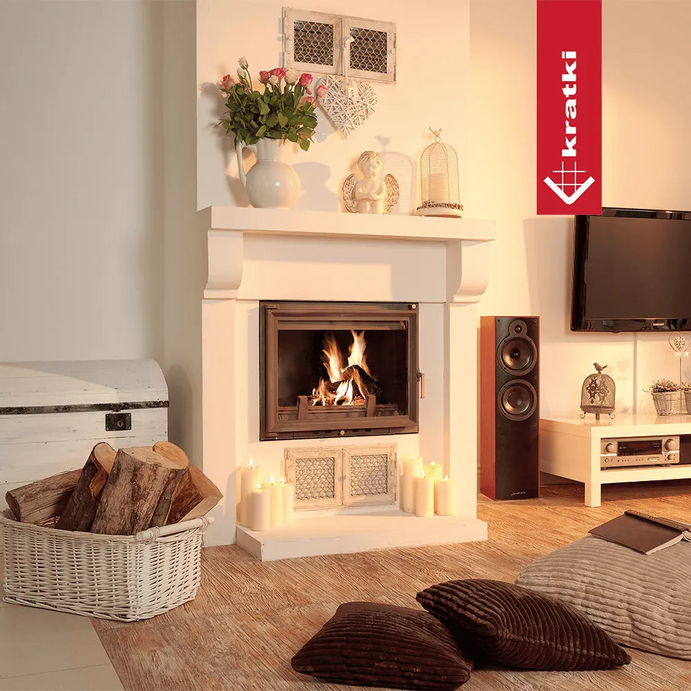 Gezellige woonkamer met brandende Kratki Zuzia haard, kaarsen, kussens en decoratieve accessoires.