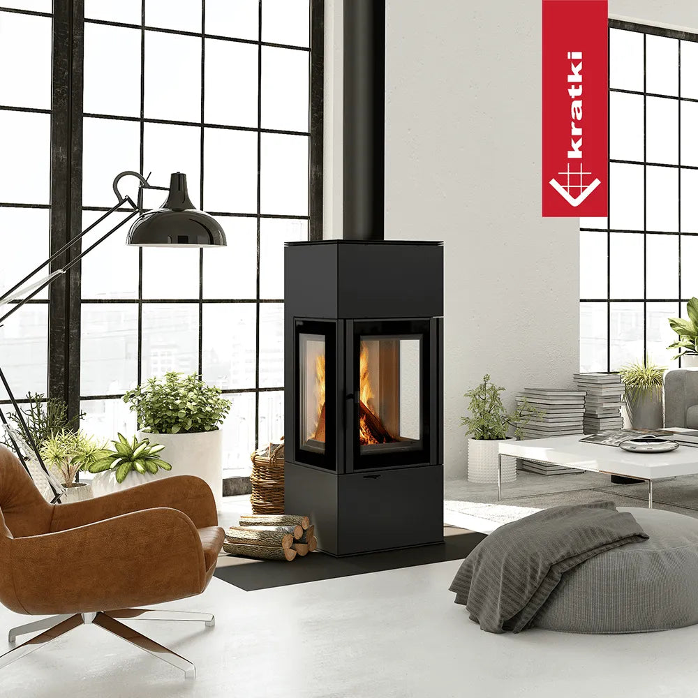Moderne woonkamer met Kratki Thor houtkachel, leren stoel, grote ramen en veel planten.