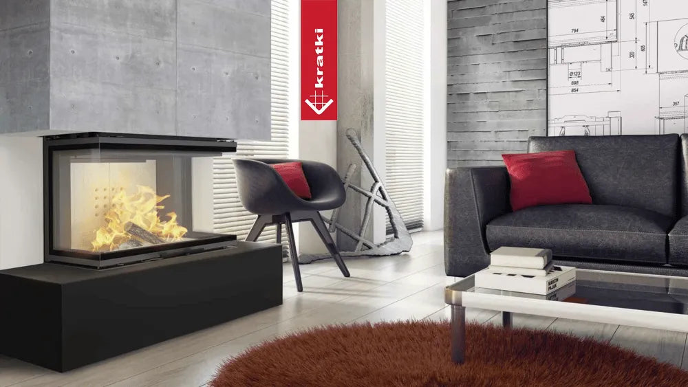 Moderne woonkamer met Kratki NBC 800/400 haard, grijze bank, rode kussens en glazen salontafel.