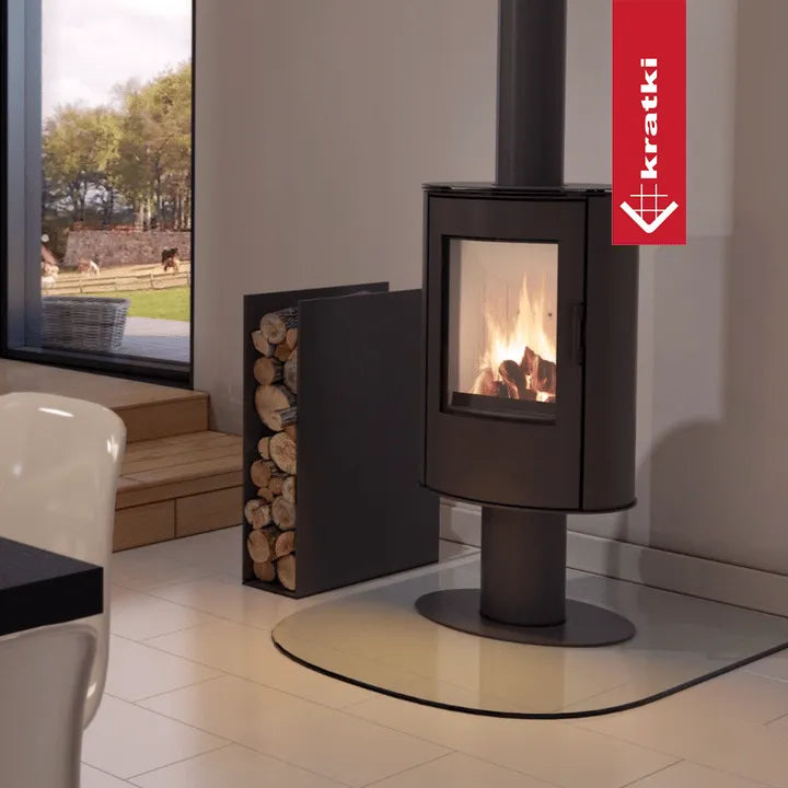 Kratki AB DR houtkachel in moderne woonkamer met groot raam en houtopslag.