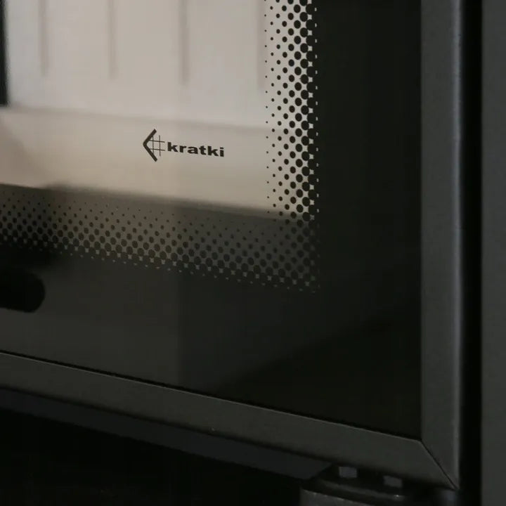 Kratki MBA Rechts, close-up van het glazen paneel met logo en stippenpatroon.
