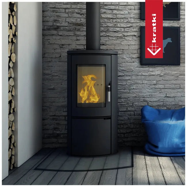 Kratki AB houtkachel in moderne woonkamer met stenen muur en stapel brandhout.
