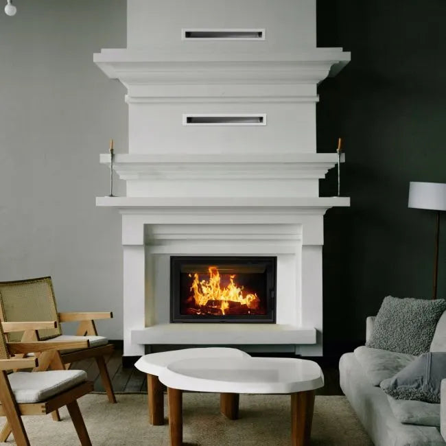 Witte woonkamer met Kratki Lucy 14 kW haard, moderne meubels en brandend vuur.