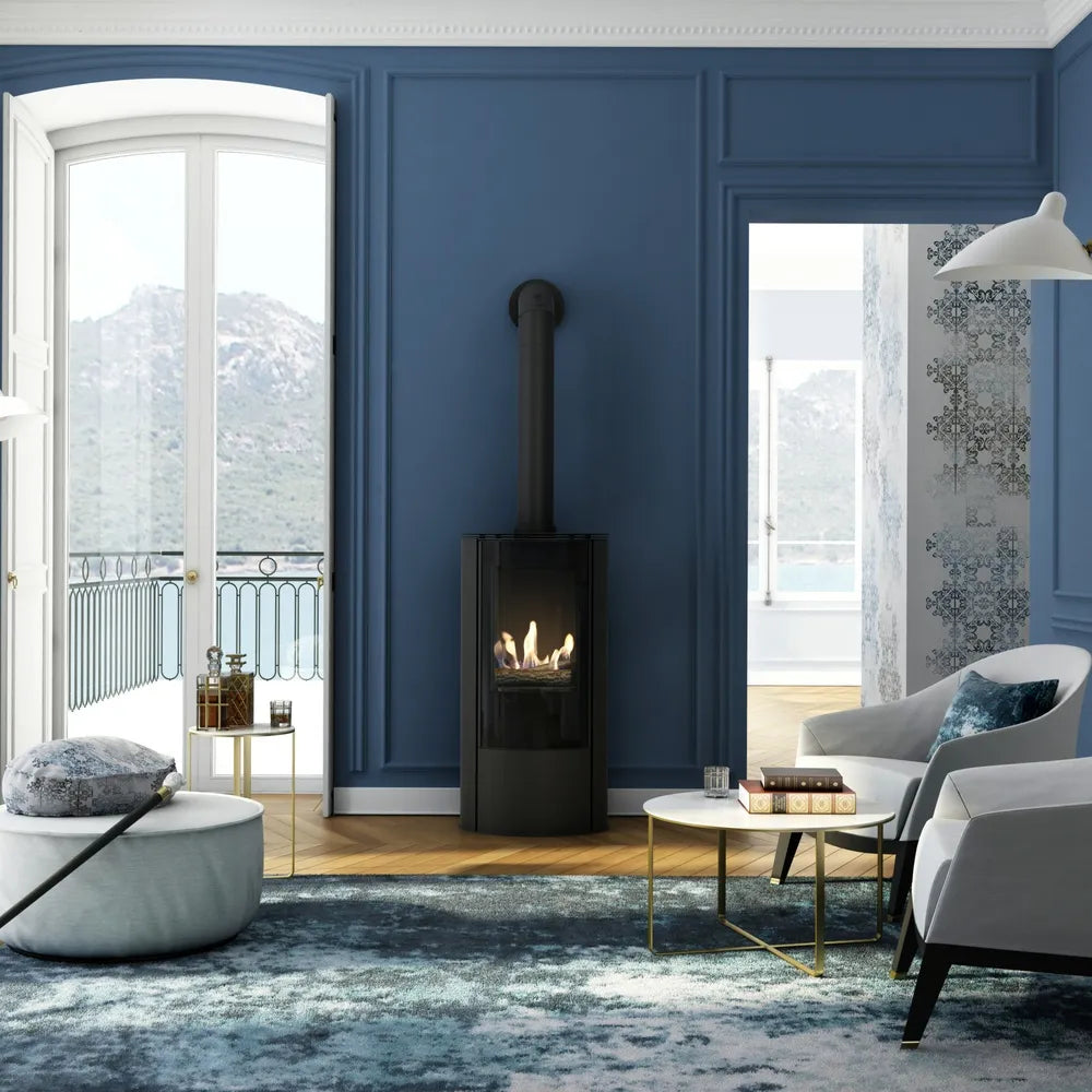 Moderne woonkamer met Kratki AB haard, blauwe muren, comfortabele stoelen en uitzicht op bergen.