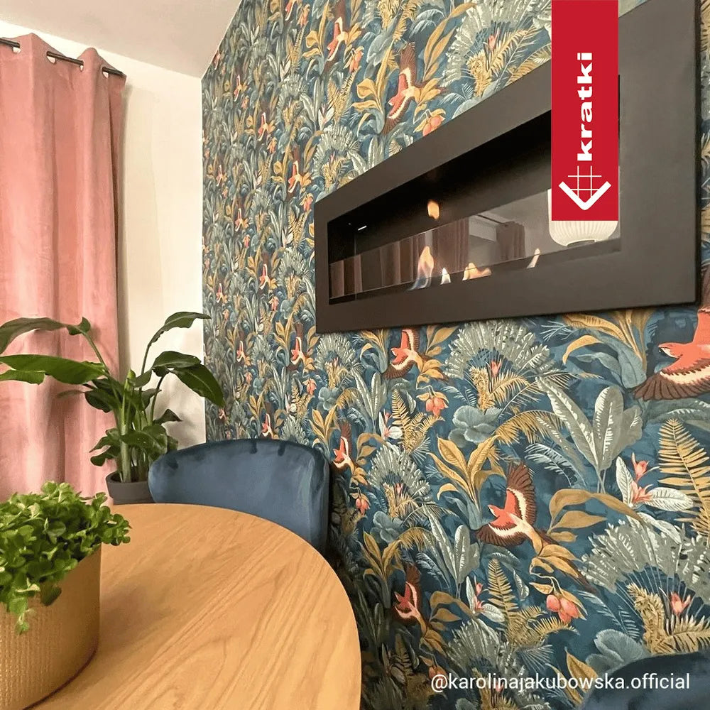 Kratki Delta2 Slim haard in kleurrijke kamer met bloemenbehang, roze gordijnen en houten tafel.