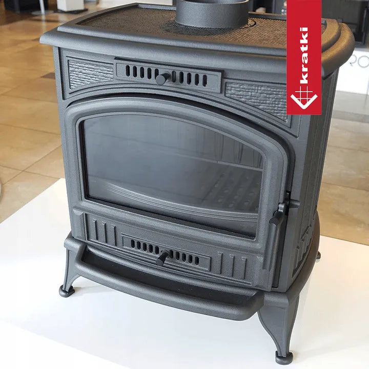 Zwarte gietijzeren houtkachel Kratki K6 met glazen deur en ventilatierooster.
