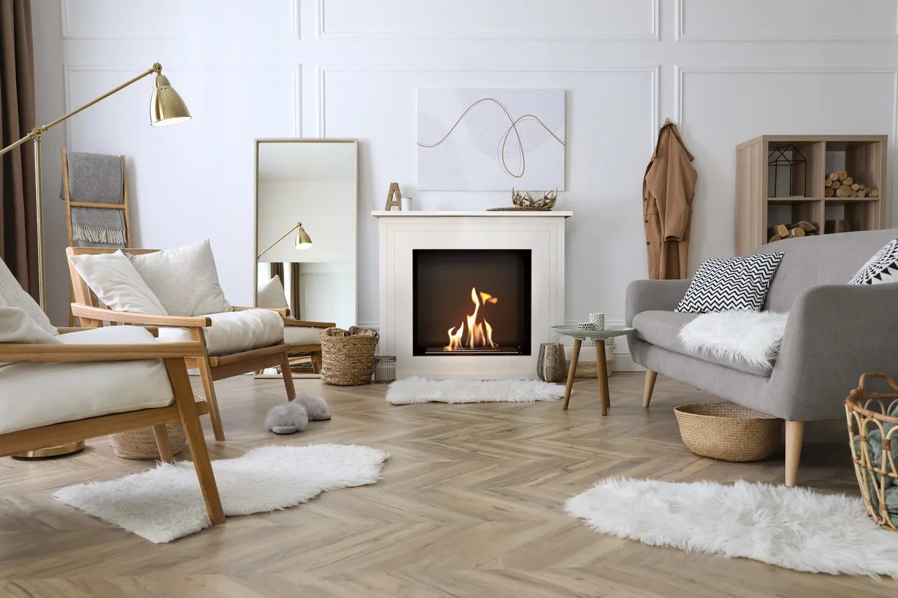 Gezellige woonkamer met Kratki June TÜV haard, houten meubels en zachte witte kleden.