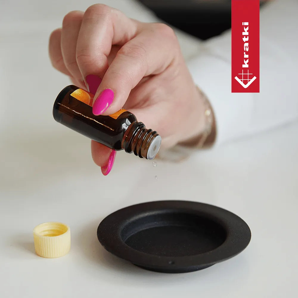 Hand met roze nagels druppelt vloeistof uit flesje in Kratki June TÜV.