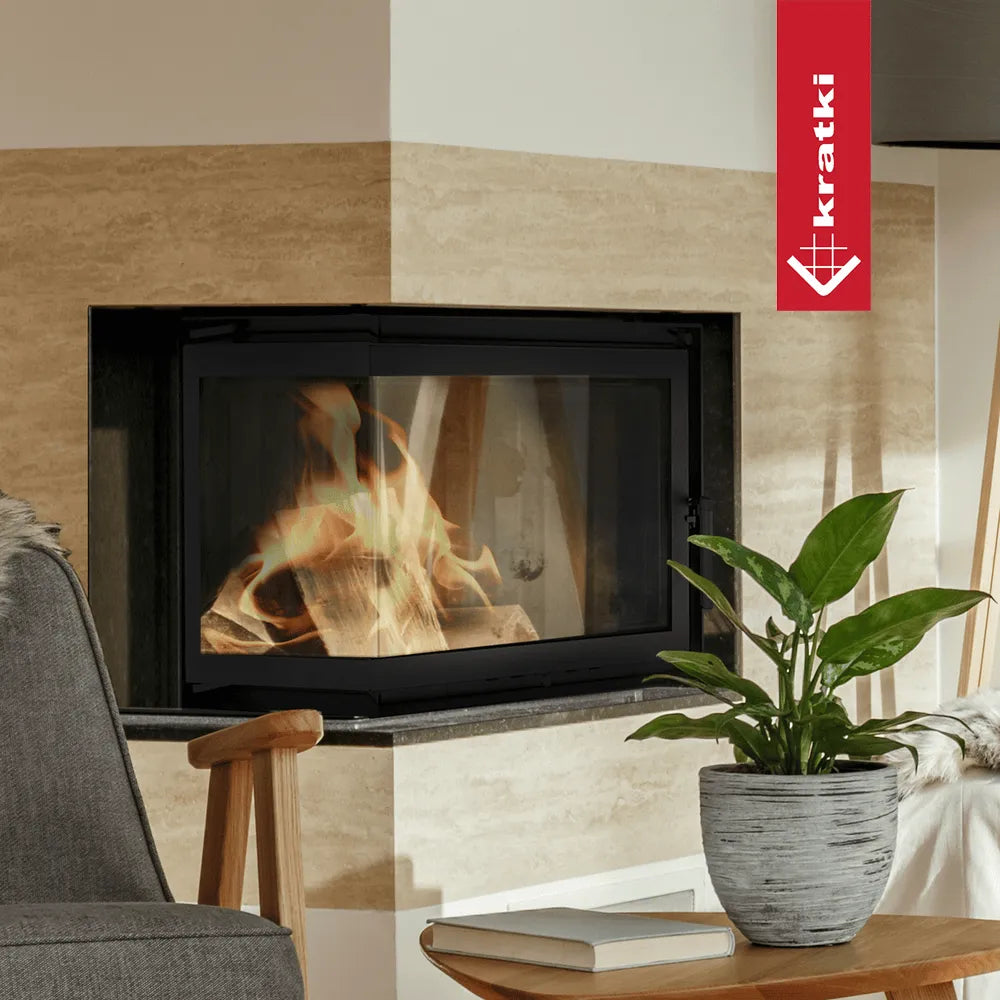 Kratki Zuzia Links haard in moderne woonkamer met plant en grijze stoel.