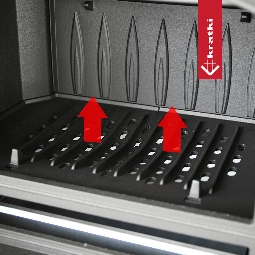 Binnenkant van Kratki K6 houtkachel met ventilatieopeningen en rode pijlen omhoog.