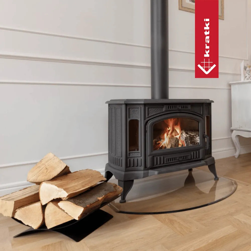 Kratki K9 houtkachel in een stijlvolle woonkamer met brandend vuur en houtblokken ernaast.