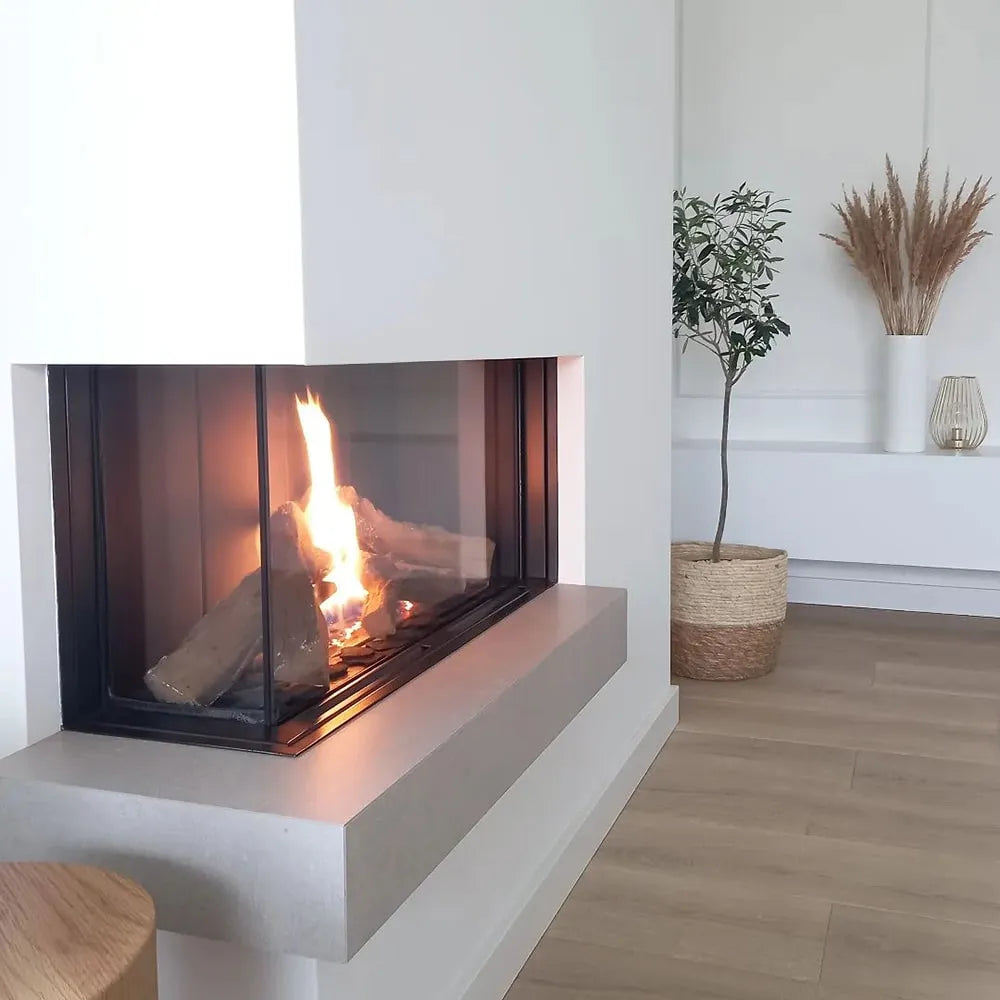 Kratki Leo 70 Links haard in een moderne, minimalistische woonkamer met houten vloer en planten.