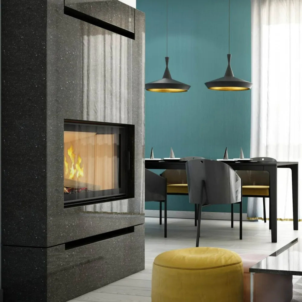 Kratki Nadia 12 kW haard in moderne woonkamer met turquoise muur en zwarte eettafel.