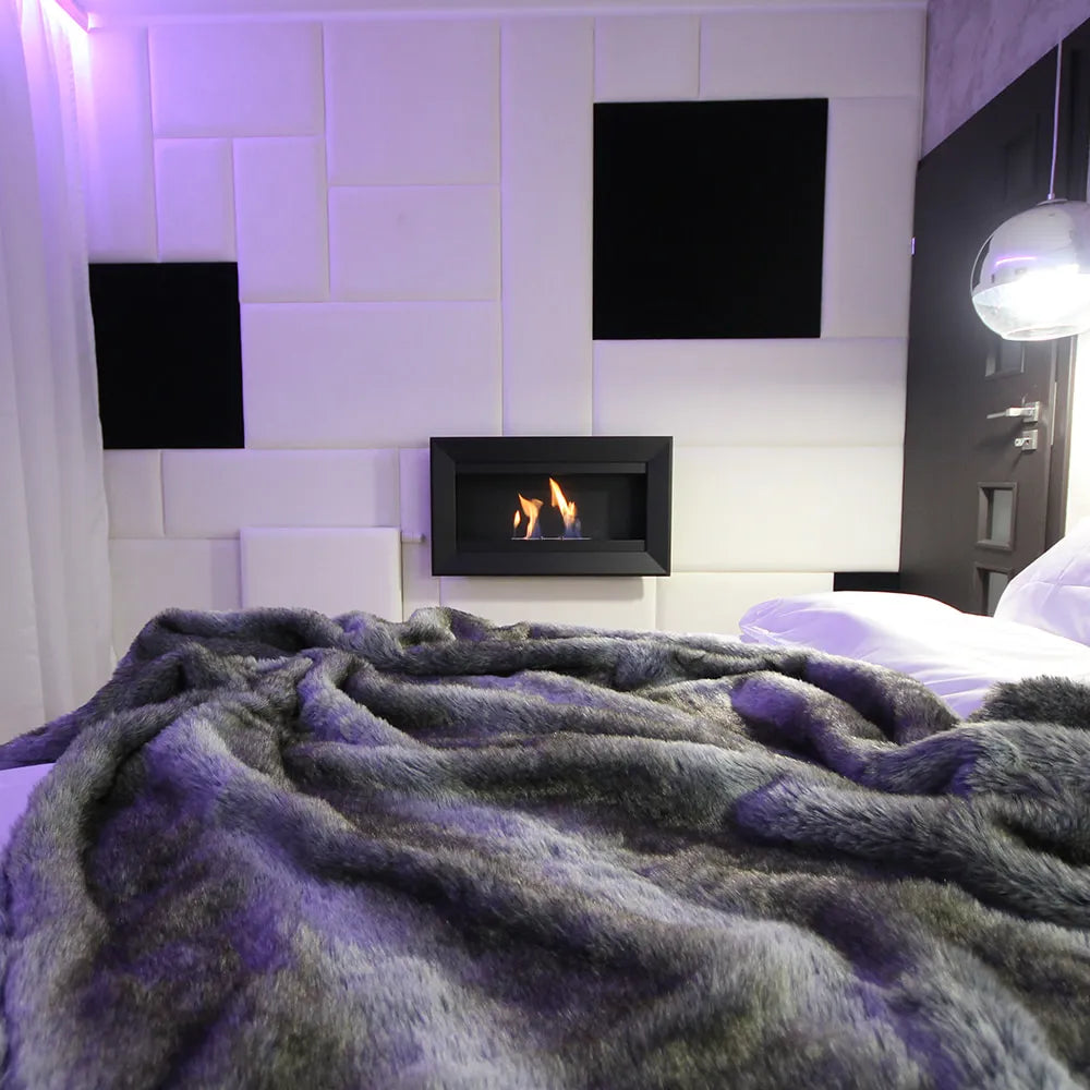 Gezellige slaapkamer met Kratki Charlie TÜV haard, zachte deken en moderne wandpanelen.