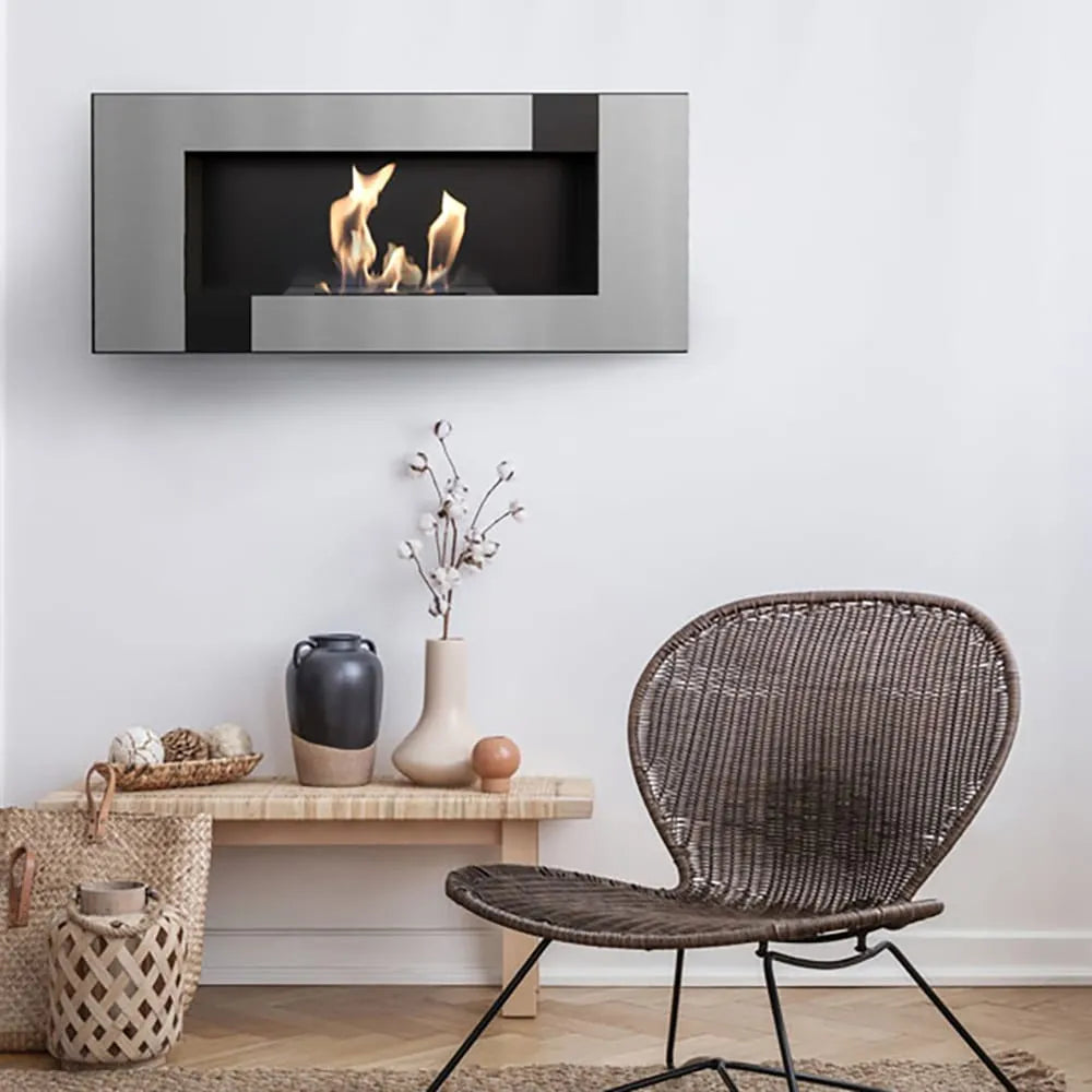 Kratki Delta2 TÜV haard in moderne woonkamer met rotan stoel en decoratieve accessoires.