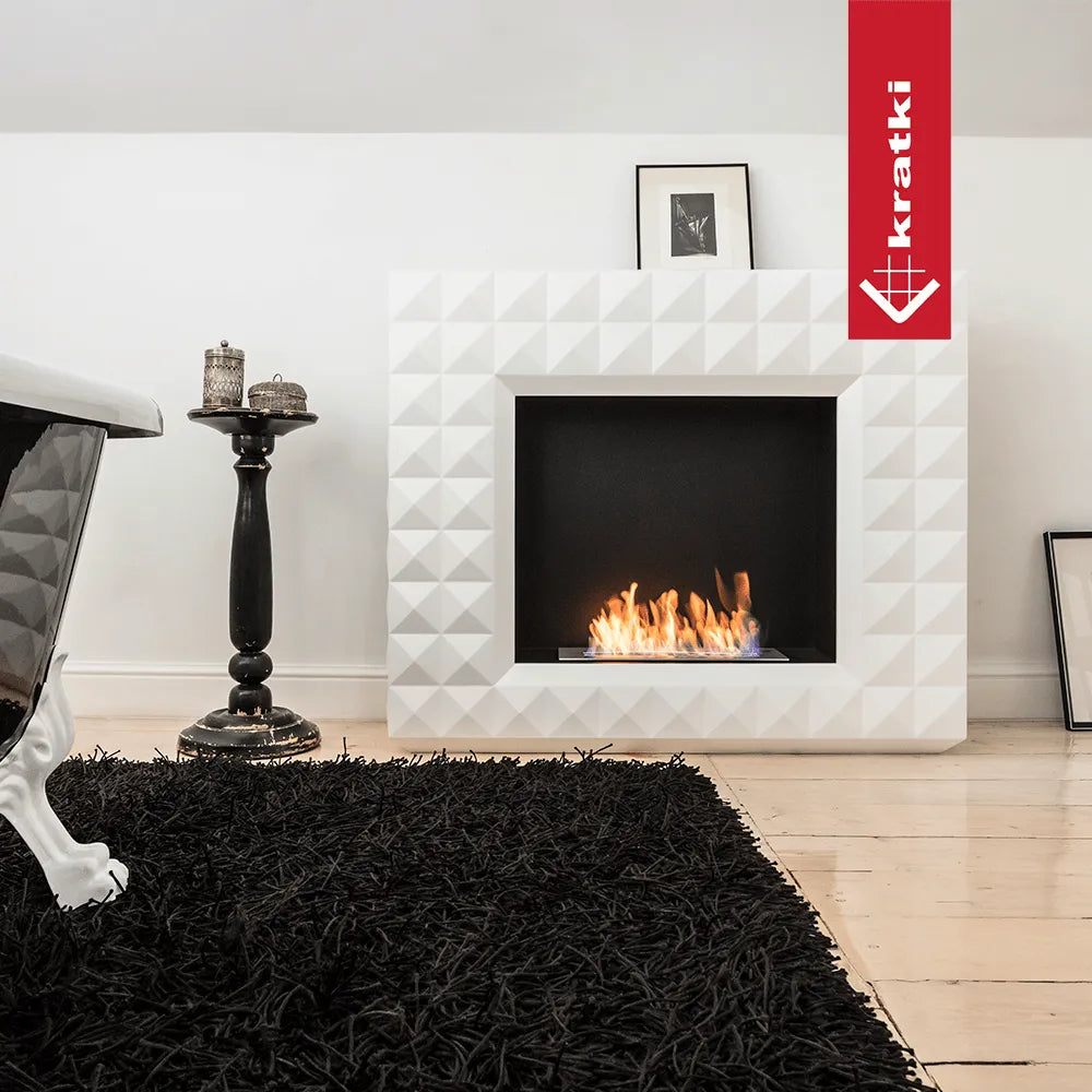 Kratki Egzul TÜV haard in moderne woonkamer met zwart vloerkleed en decoratieve bijzettafel.