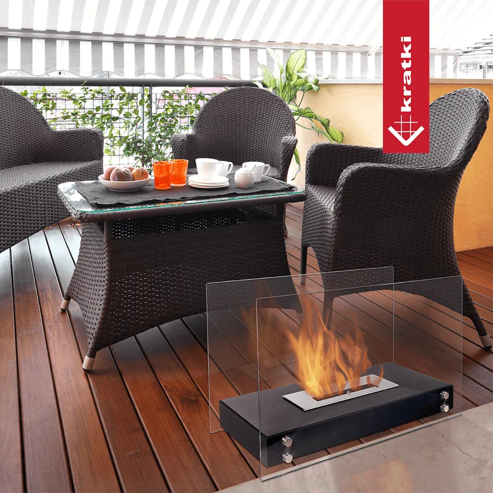 Gezellige zithoek op terras met Kratki Hotel TÜV haard, rieten meubels en koffie op tafel.