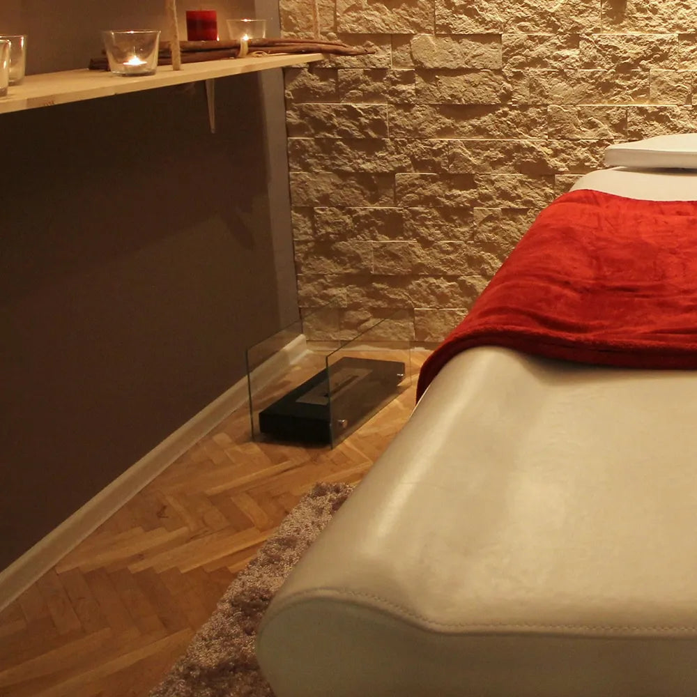 Gezellige spa-ruimte met Kratki Hotel TÜV haard, kaarsen en massagetafel met rood deken.