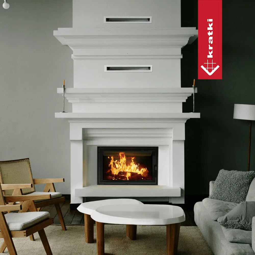 Witte woonkamer met brandende Kratki Lucy 14 kW haard, moderne meubels en houten accenten.