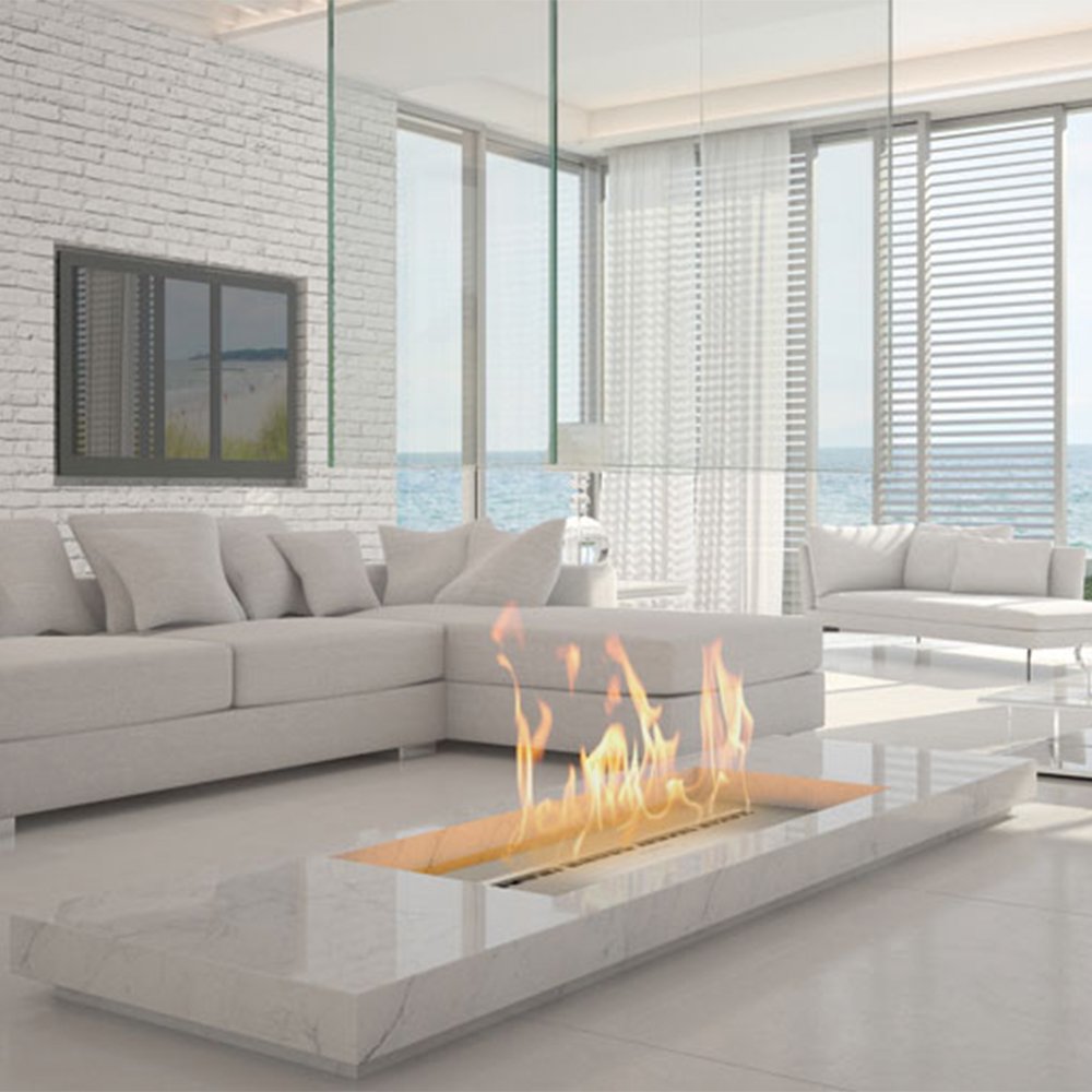 Woonkamer met Icon Fires Slimline brander 1400mm, moderne inrichting en uitzicht op zee.