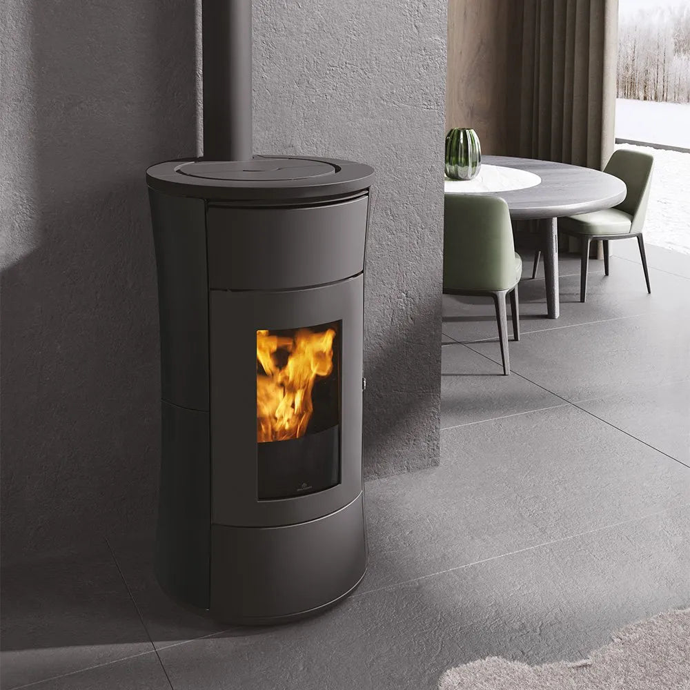 Edilkamin Cherie 11 Evo Air Tight C pelletkachel in een moderne woonkamer met een ronde eettafel.