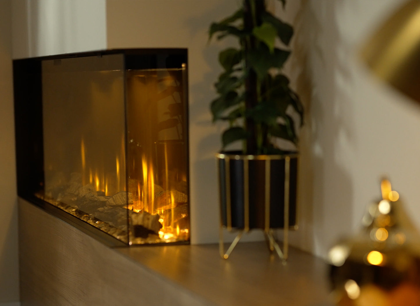 Dimplex Ignite Bold 74 elektrische haard met realistisch vlameffect, naast een plant in een zwarte pot.