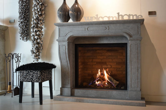 Schouw Model 103 in een showroom met brandend vuur en stenen omlijsting