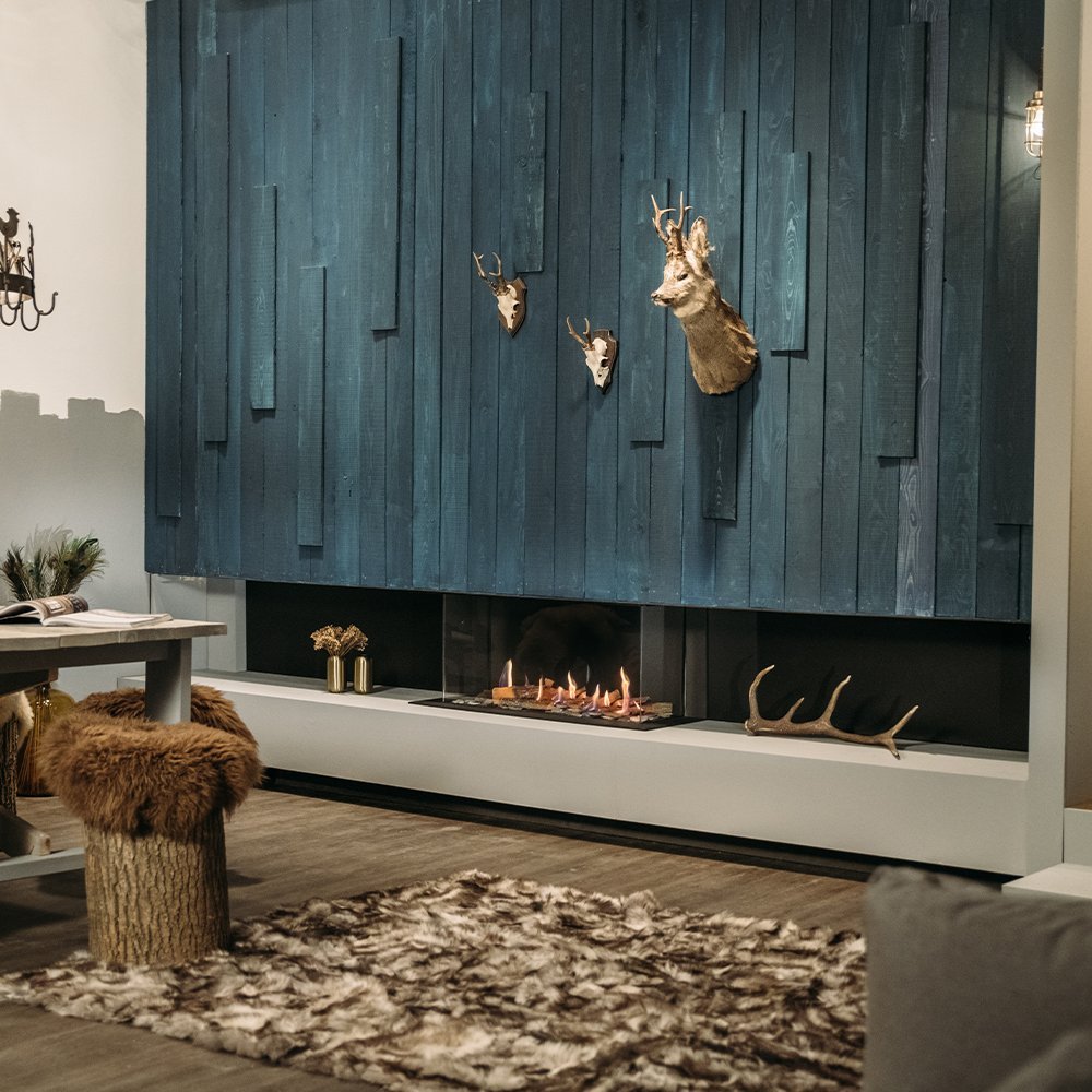 Faber MatriX 800/400 III 3-zijdig haard in een modern ingerichte woonkamer met blauwe houten wand.