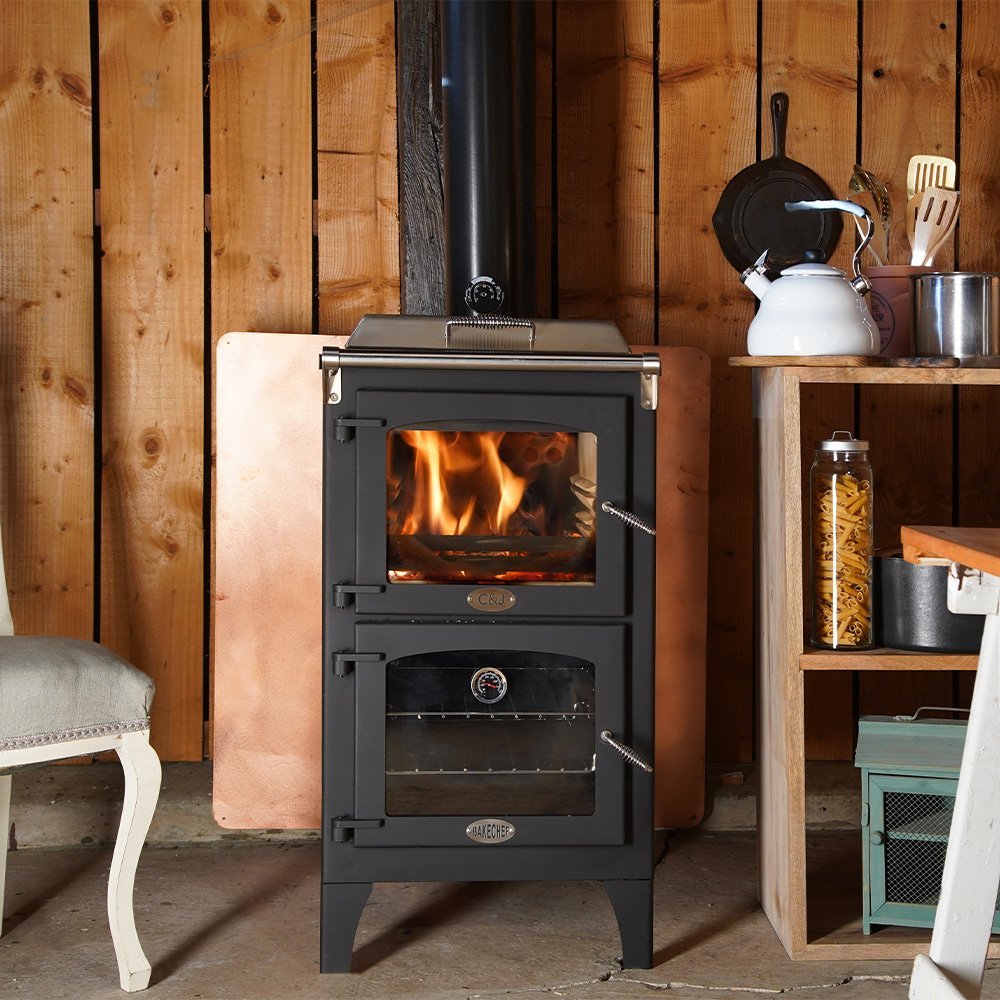 Charlton & Jenrick Go Eco Bake Chef houtkachel in een rustieke keuken met houten muren.