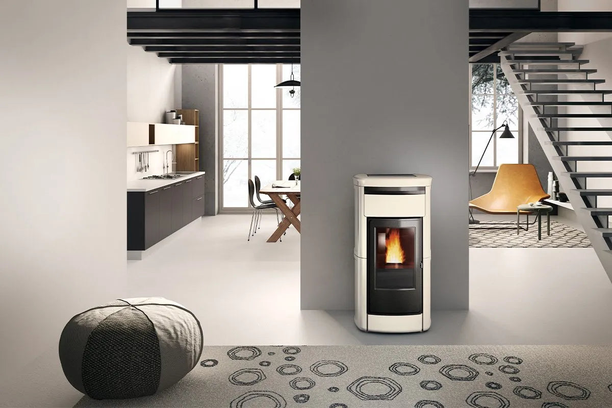 Moderne woonkamer met Edilkamin Kira2 H 22 Up pelletkachel, naast een open keuken en trap.