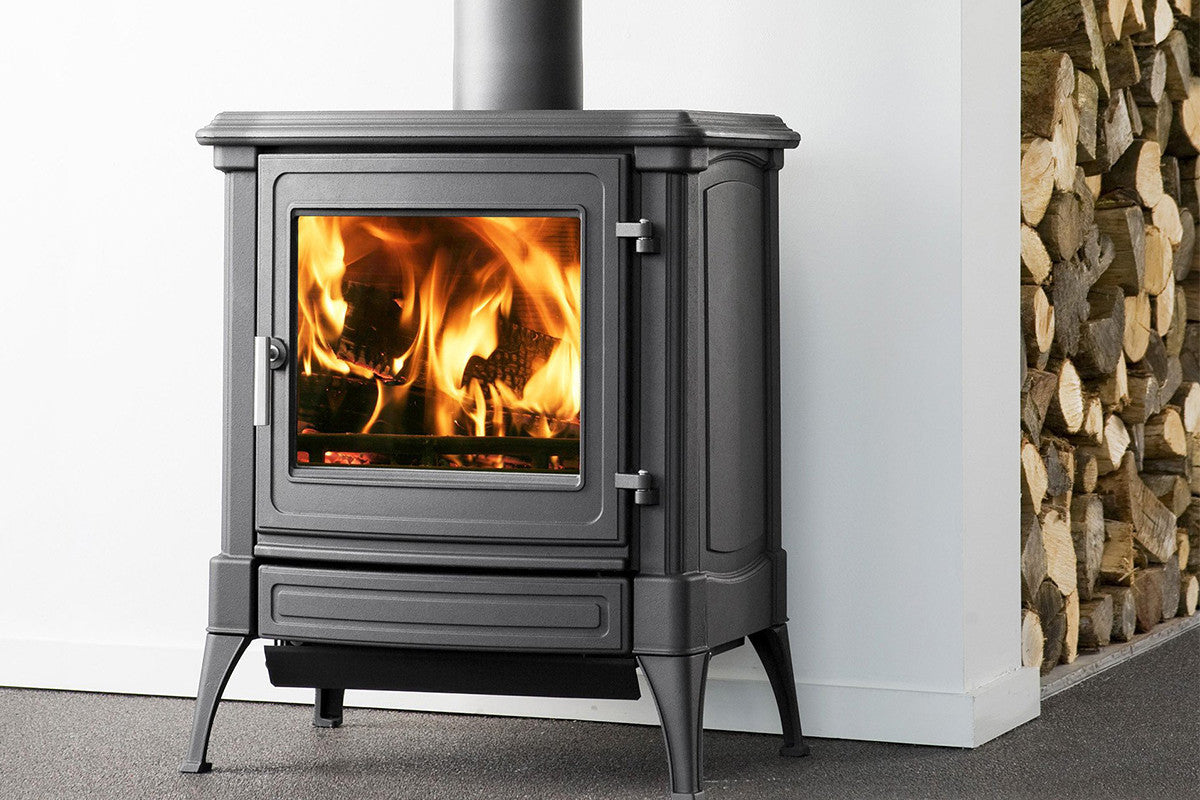 Nestor Martin S33 houtkachel met brandend vuur in een witte ruimte