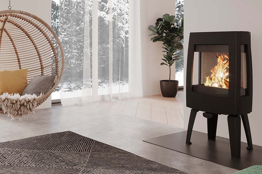 Dovre Sense 303 houtkachel in moderne woonkamer met hangstoel en plant