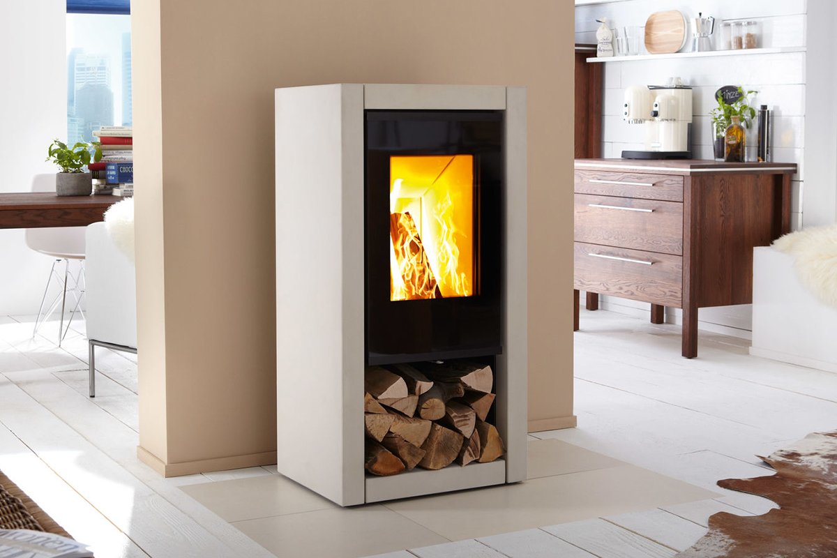 Spartherm Ambiente A7 houtkachel in een moderne woonkamer met houtopslag onderin.