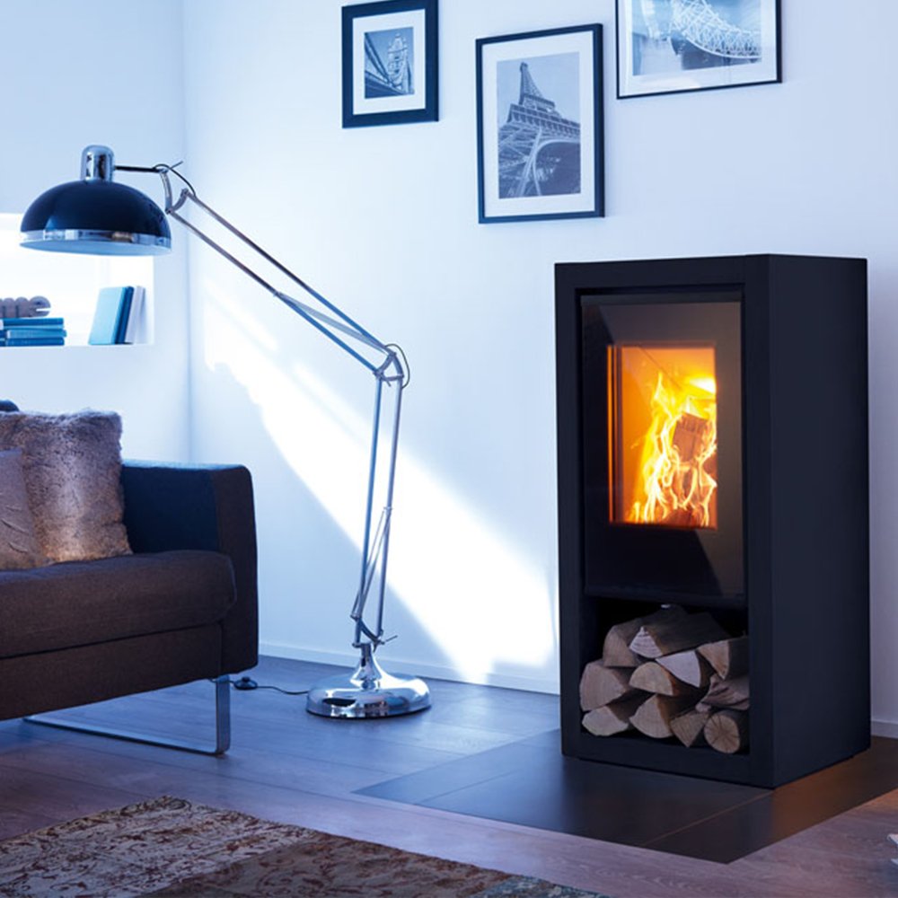 Spartherm Ambiente A7 houtkachel in een moderne woonkamer met een vloerlamp en wanddecoraties.