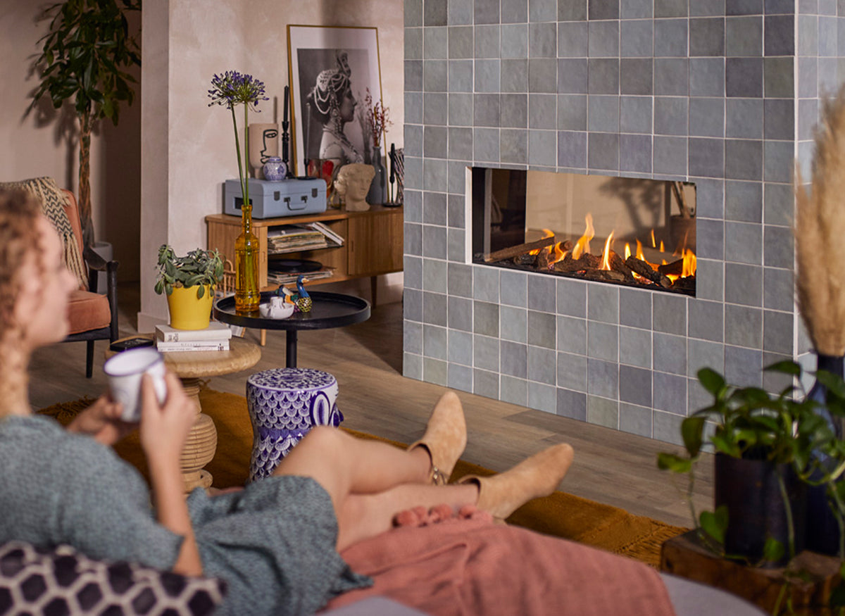 Trimline Fires 100 Tunnel ingebouwd in tegelwand in woonkamer met brandende haard.