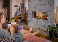 Trimline Fires 100 Tunnel ingebouwd in tegelwand in woonkamer met brandende haard.