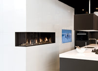 Trimline Fires 140 Corner ingebouwd in moderne witte keuken, met vlammen zichtbaar