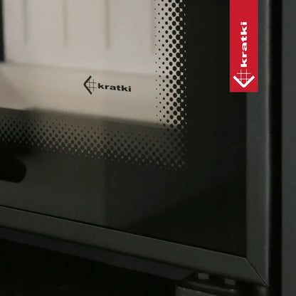 Close-up van de Kratki MBO houtkachel met logo en geperforeerd glas.