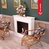 Kratki November haard in woonkamer met twee rieten stoelen en bloemen