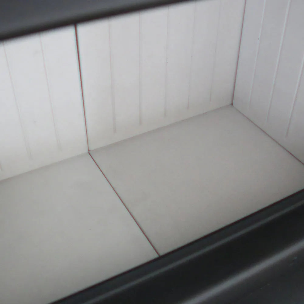 Binnenkant van de Kratki MB100 haard met witte bekleding en zwarte rand.