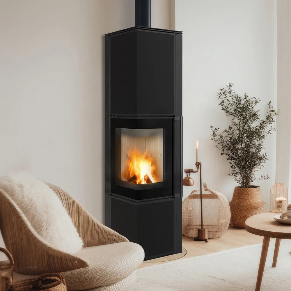 Kratki Tora L houtkachel in een moderne, gezellige woonkamer met comfortabele stoel en decoratie.