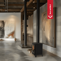 Kratki K11 houtkachel in moderne showroom met kunstwerken en hoge plafonds