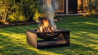 Balstil Ember vuurkorf met brandend hout in een verlichte tuin
