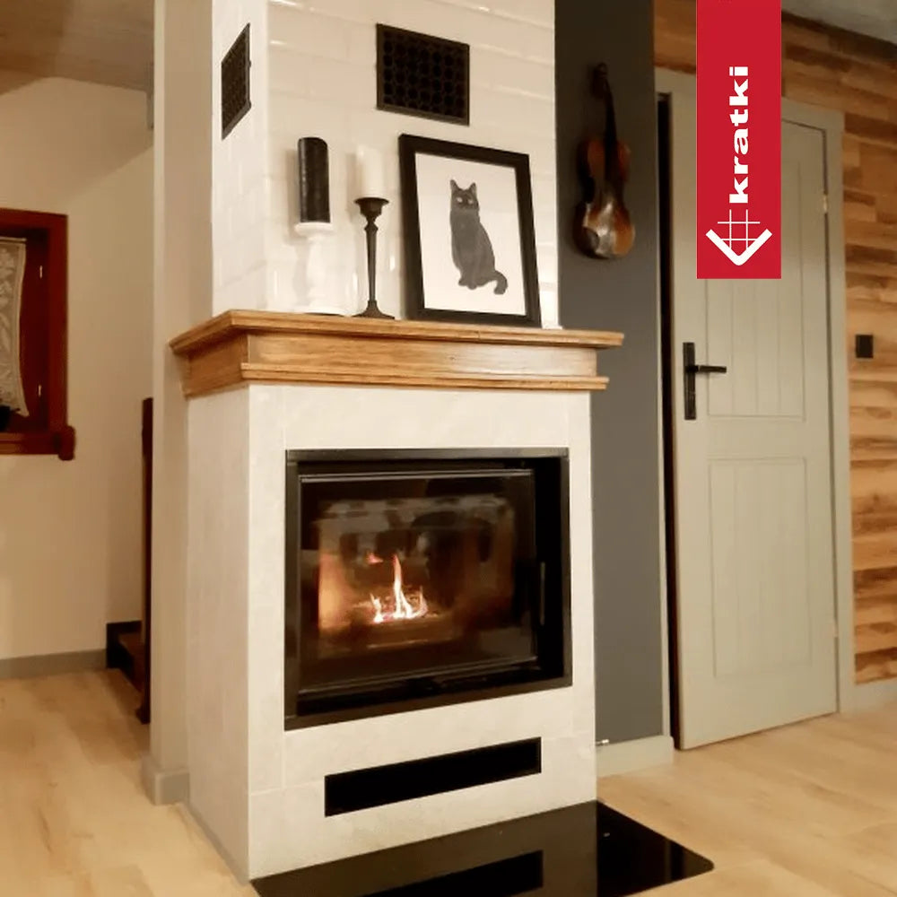 Kratki Zuzia Eco haard in een gezellige woonkamer met houten accenten en decoratieve elementen.