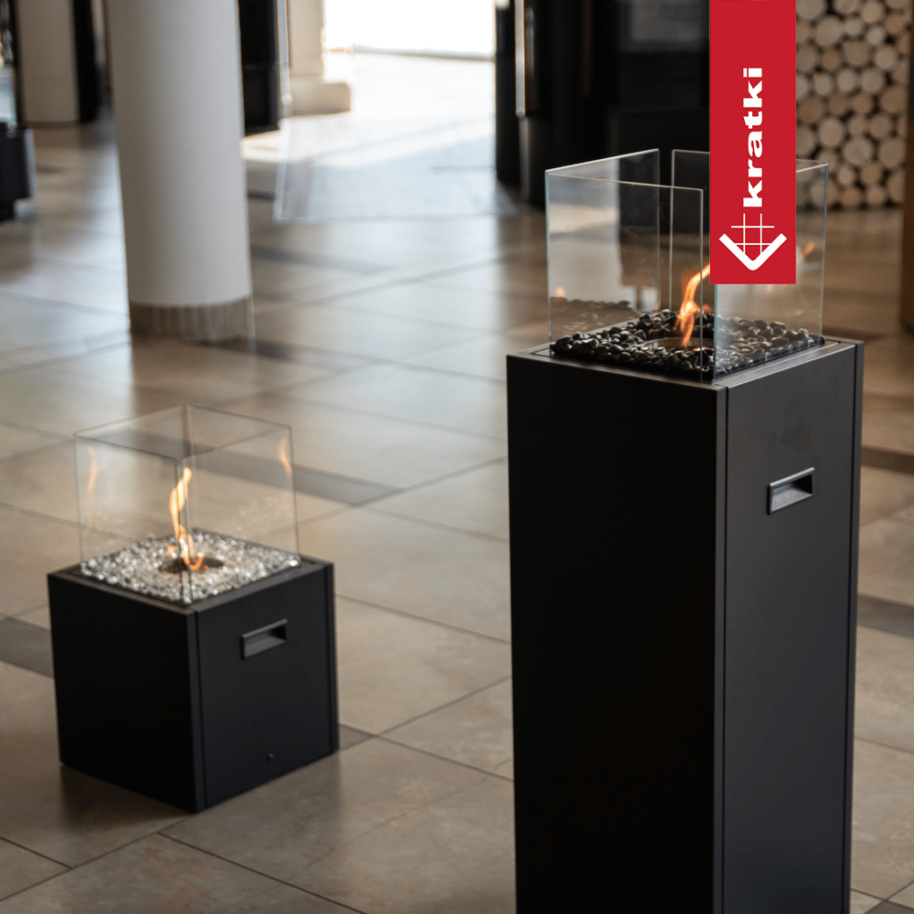Kratki Tower haard op showroomvloer met glazen vuurkorf en vlam