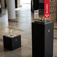 Kratki Tower haard op showroomvloer met glazen vuurkorf en vlam