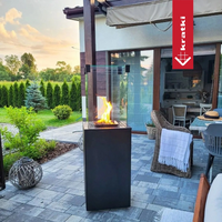 Kratki Patio Mini terrasvuur met brandende vlammen op een sfeervol terras naast een tuin