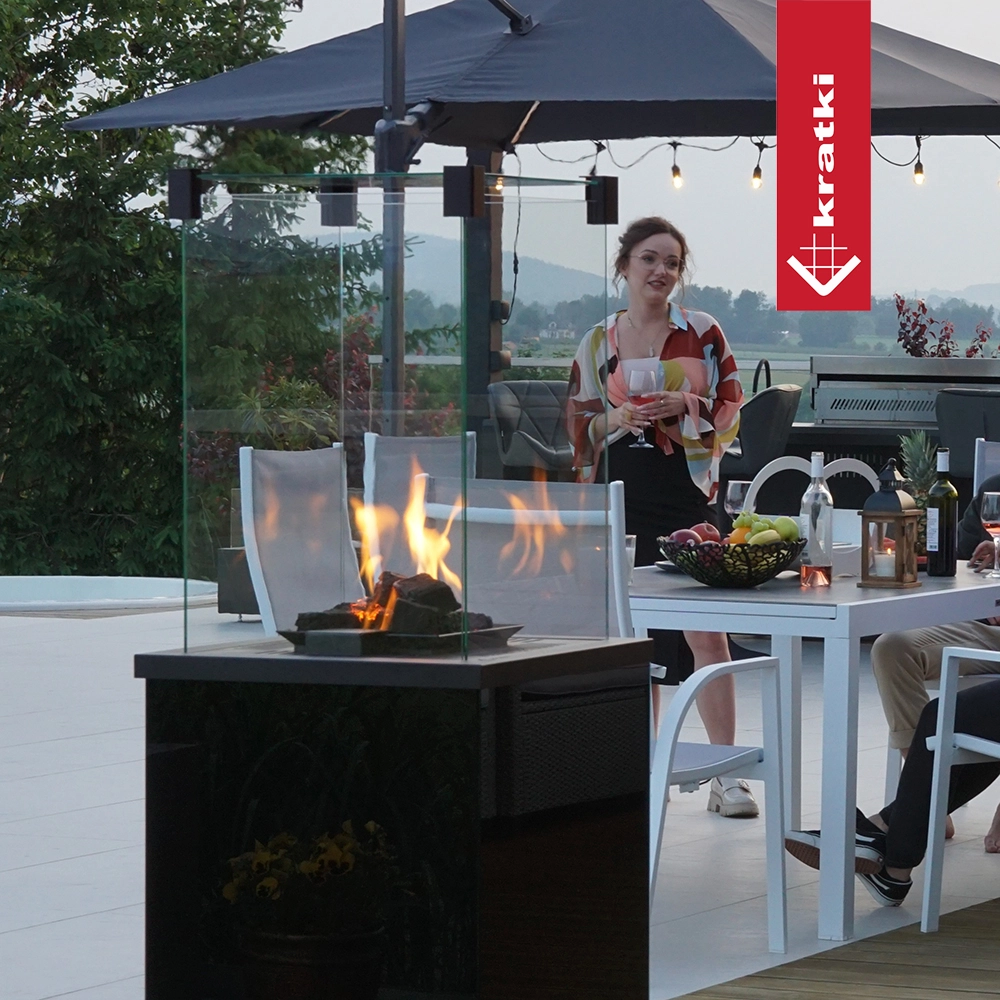 Kratki Patio Mini terrashaard met vlammen naast eettafel buiten