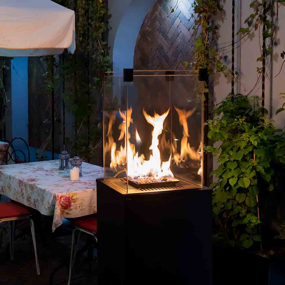 Kratki Patio Mini met brandend vuur op een terras naast een gedekte tafel
