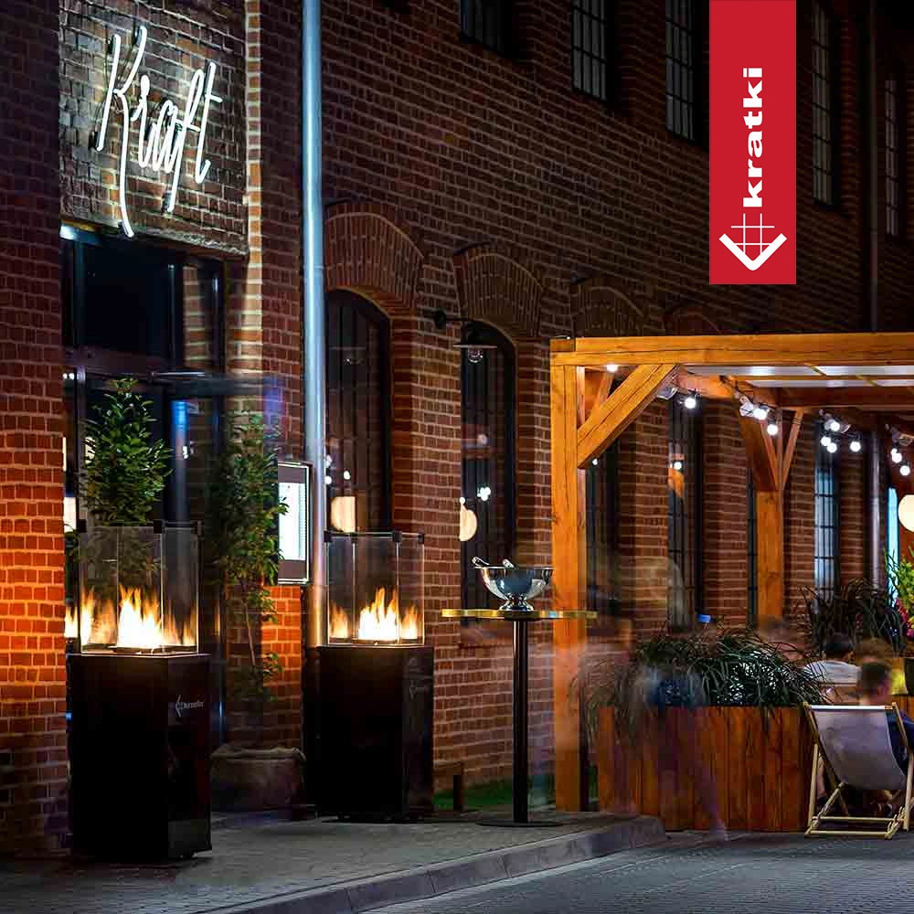 Kratki Patio Mini terrasheater bij bakstenen gevel en pergola